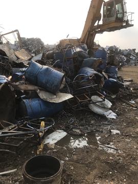 GetMyScrap | Scrap Metal Pile with Blue Drums and Heavy Machinery